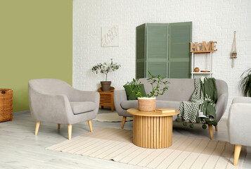 Obraz premium Stylish interior of modern living room with bamboo stems and sofa