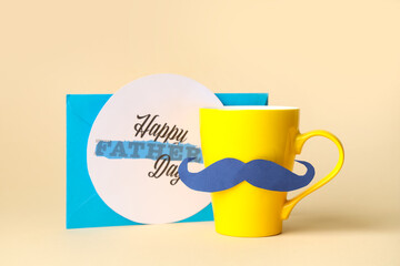Cup with mustache and paper with text HAPPY FATHER'S DAY on beige background
