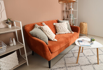 Interior of stylish living room with brown sofa and coffee table near beige wall