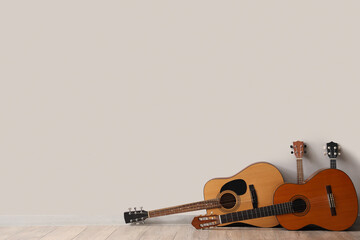 Different guitars near white wall