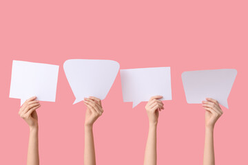 Female hands with speech bubbles on pink background