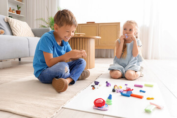 Little children sculpting from plasticine on floor at home