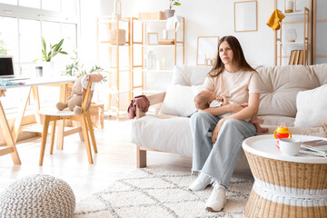 Stressed young mother suffering from postnatal depression at home