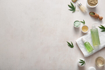 Bottles and jars of hemp cosmetic products with powder and leaves on white background