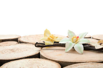 Aromatic vanilla pods and flowers on table against white background