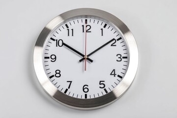 A wall clock is displayed showing the time at 101000 It features a silver frame and a white face with clear numeral markings