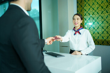 Businessman and his assistant are proceeding a checkin at airline counter in the airport.