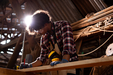 Professional African male carpenter is working professionally in sawmill - workshop.