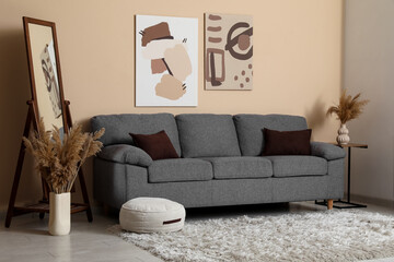 Comfortable grey sofa and mirror in interior of living room