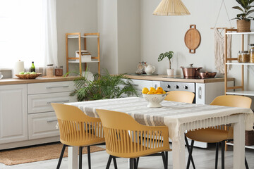 Interior of light kitchen with counters, shelf units and dining table