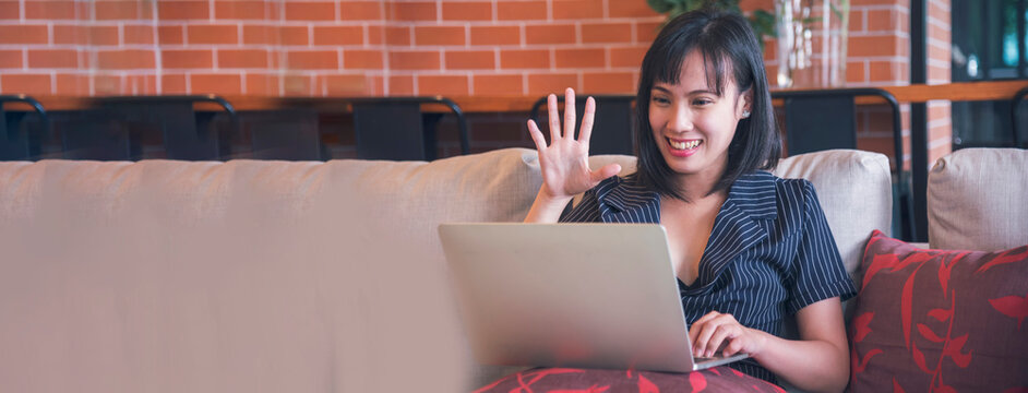 Banner Asian Woman using laptop working from home online meeting in home office. Banner Happy relax time asian business woman typing keyboard notebook laptop Smiling at home office with copy space