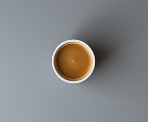 A minimalistic view presents a cup of coffee with milk on a solid gray surface, perfect for breakfast, cafe menus or showcasing warm drinks and coffee culture.