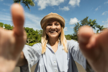 Woman with a bright smile invites you closer in a vibrant park