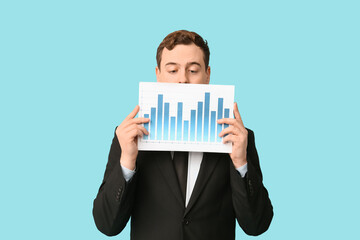 Young businessman with diagrams on blue background