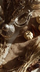 Flat lay of autumn centerpiece: dried wheat stalks, mini pumpkins, cinnamon sticks on burlap runner, vintage silver gravy boat, soft morning light 