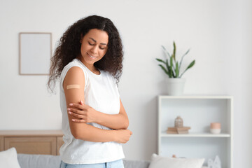 Young African-American woman with medical patch after vaccination at home
