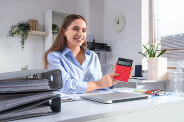 Female accountant with calculator at desk in office