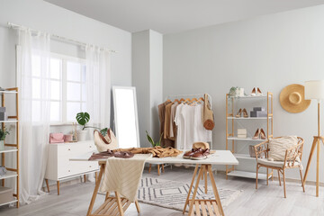 Interior of clothes stylist's studio with workplace and mirror