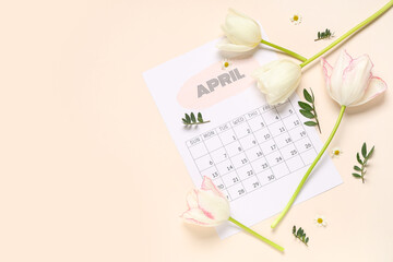 Composition with paper calendar of April and beautiful spring flowers on color background