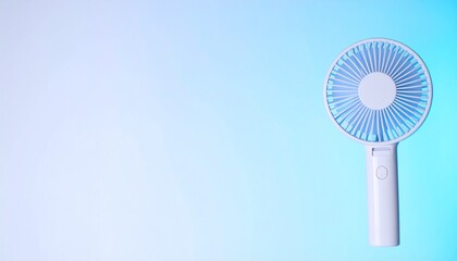 透明感あるアイシーブルーからホワイトへの背景に、右上隅でハンドミストファンが夏の涼風をイメージさせるシンプルで爽やかなビジュアル

