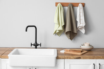 Counter with sink, utensils and clean towels in kitchen