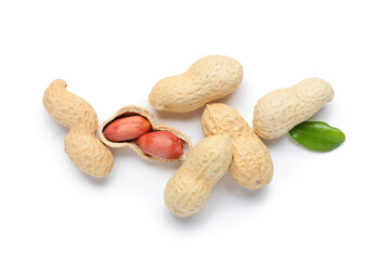 Many unpeeled peanuts and leaf on white background