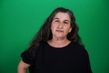 Fototapeta premium Unedited Portrait of Woman’s Face Expressing Various Emotions – Green Studio Background