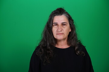 Fototapeta premium Unedited Portrait of Woman’s Face Expressing Various Emotions – Green Studio Background