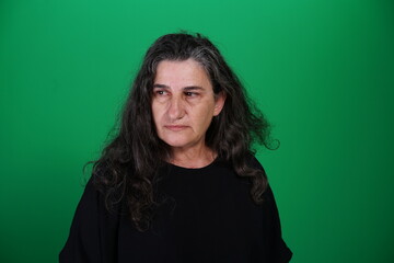 Fototapeta premium Unedited Portrait of Woman’s Face Expressing Various Emotions – Green Studio Background