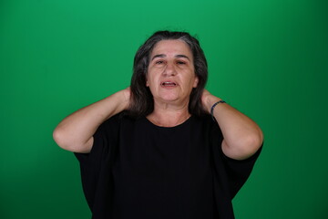 Woman with a variety of emotions, wearing a black t-shirt ,standing against a green background....