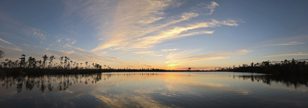 Panorama of colorful sunset cloudscape over Pine Glades Lake in Everglades National Park, Florida. - Powered by Adobe