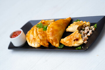 Empanada argentina de matambre en plato negro 