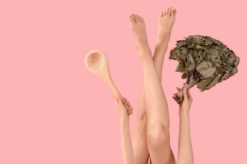 Young woman with sauna whisk and wooden spoon on pink background