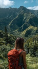 Naklejka premium A woman with a backpack stands among tropical plants, gazing at dramatic green mountain peaks under a moody, cloud-covered sky.