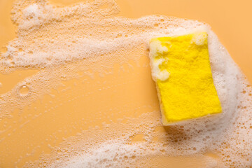 Sponge for cleaning and foam on beige background