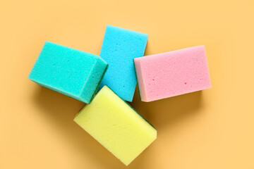Sponges for cleaning on beige background, top view