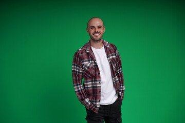 Young man with a variety of emotions, standing against a green background. Studio shot with copy space.