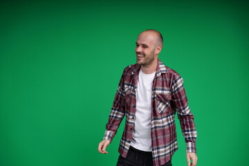 Fototapeta premium Young man with a variety of emotions, standing against a green background. Studio shot with copy space.