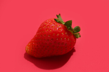 Sweet ripe strawberry on red background
