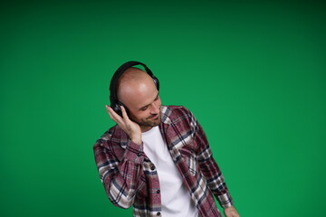 Young man with a variety of emotions, wearing a white t-shirt standing against a green background. Studio shot with copy space.