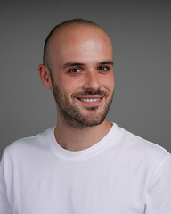 Fototapeta premium Young man with a variety of emotions, wearing a white t-shirt standing against a green background. Studio shot with copy space.