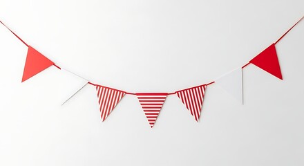 Obraz premium Red and white striped triangular flags strung in a festive garland against a plain white background.