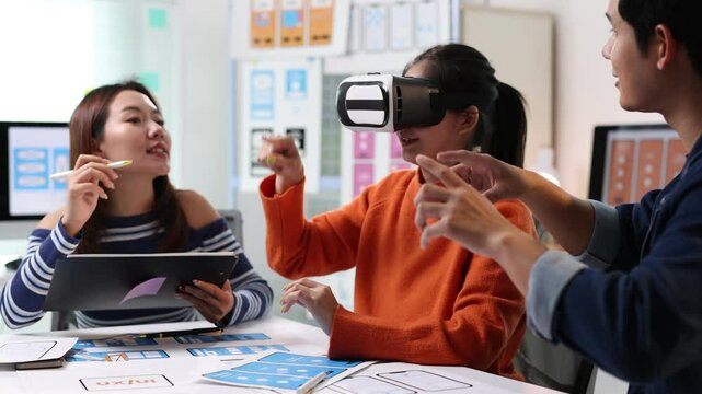 Collaborative software development team analyzing virtual reality interface design, evaluating mobile application user experience and innovative technological functionalities in modern workplace.