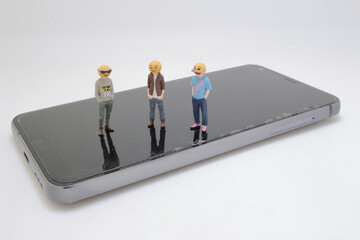 Miniature Figures of Emoji Characters On a Smartphone Surface