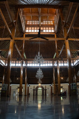 Fototapeta premium Interior view of Masjid Agung Surakarta, showcasing grand chandeliers, traditional wooden pillars, and serene architecture.