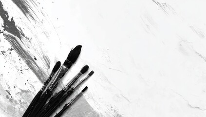 Black paintbrushes on a white textured surface