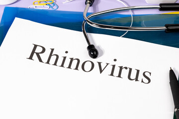 A Paper with “Rhinovirus” Title in Clipboard Set on the Desk with Stethoscope – Common Cold...