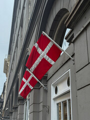 Two flags of Denmark. Copenhagen street with danish flags on building facade.