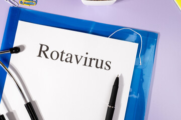 A Paper with “Rotavirus” Title in Clipboard Set on the Desk with Stethoscope – Infant...