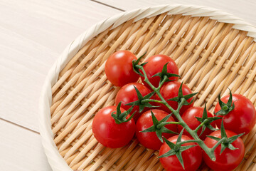 Fresh cherry tomatoes on a bamboo colander. 竹ザルの上の新鮮なミニトマト	